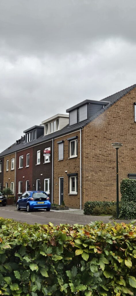 Dakkapel in Breda geplaatst op rijtjeswoning in woonwijk met meerdere dakkapellen zichtbaar